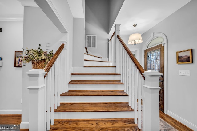 stairway featuring crown molding and hardwood / wood-style floors