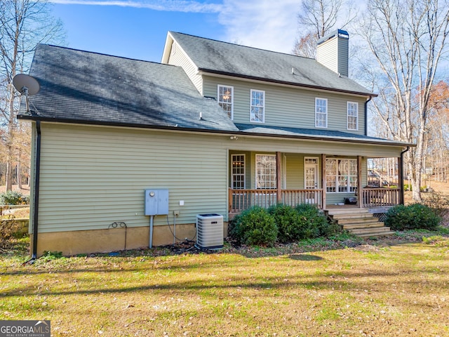 rear view of house featuring a porch, a lawn, and central air condition unit