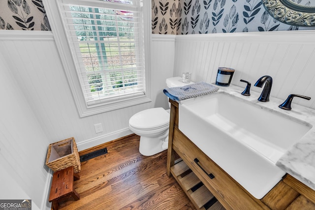 bathroom featuring wood-type flooring, toilet, and vanity