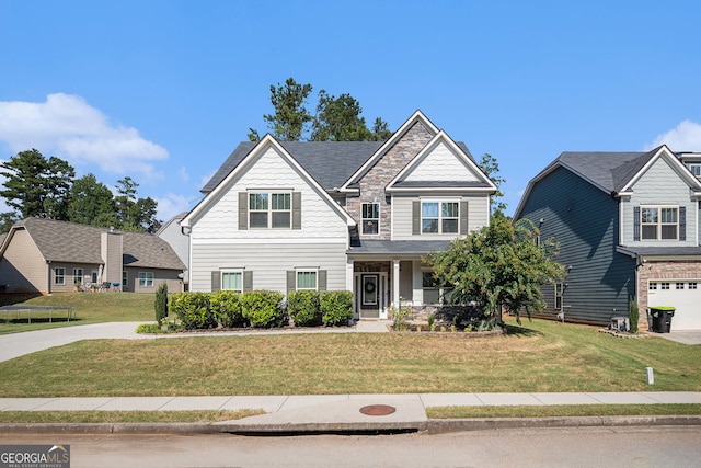 craftsman house featuring stone siding, a front lawn, and concrete driveway