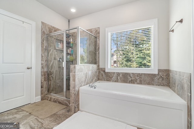 bathroom featuring a shower stall and a bath