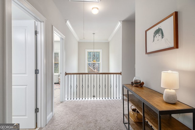 corridor with attic access, carpet flooring, and crown molding