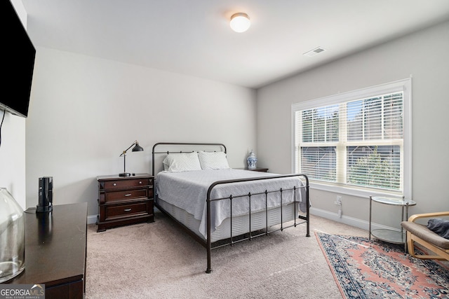 bedroom with light colored carpet, visible vents, and baseboards