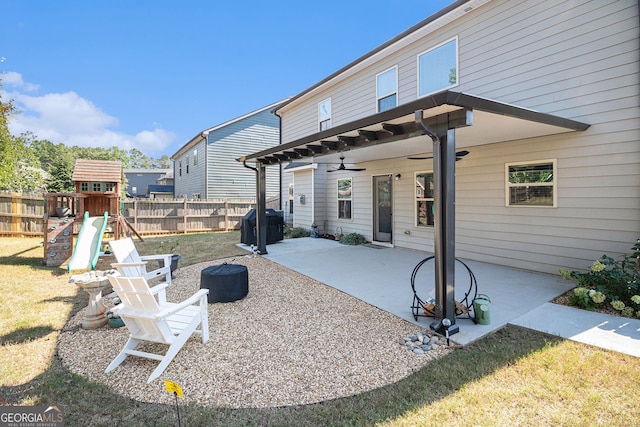 rear view of property with a playground, a patio, a lawn, ceiling fan, and fence