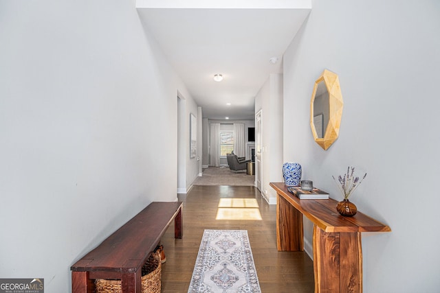 corridor featuring baseboards and wood finished floors