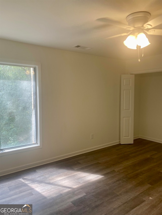 unfurnished room with ceiling fan, plenty of natural light, and dark hardwood / wood-style floors