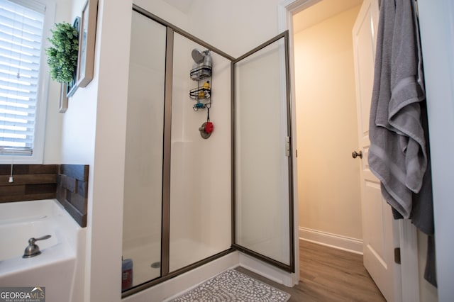 full bathroom featuring a shower stall and wood finished floors