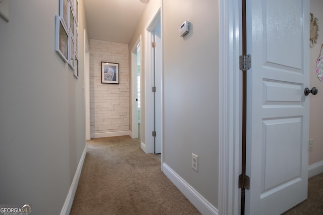 hall featuring baseboards and carpet flooring