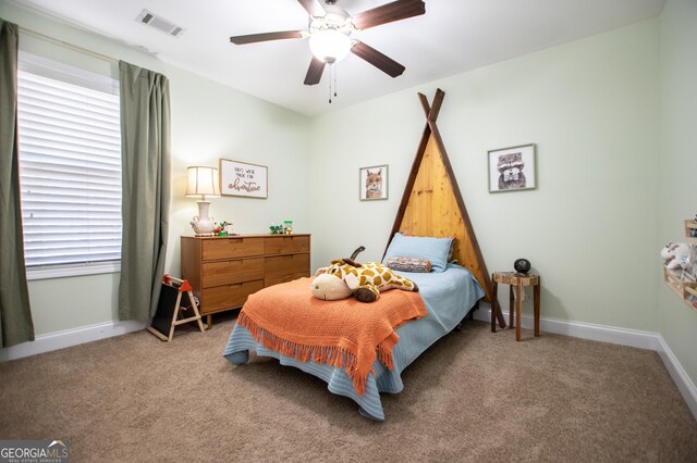 bedroom featuring a ceiling fan, light colored carpet, visible vents, and baseboards