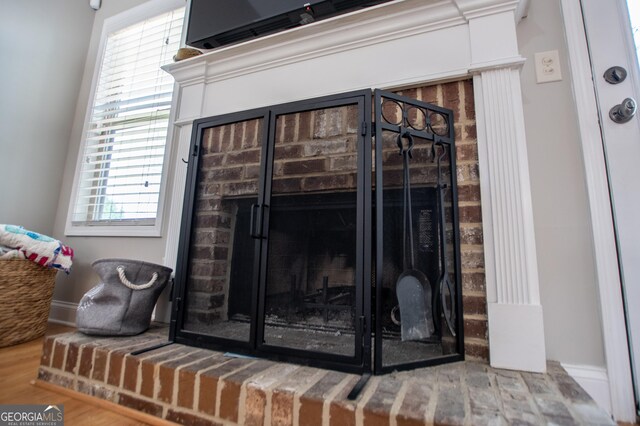 interior details with hardwood / wood-style flooring and a brick fireplace