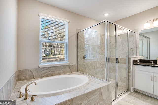 bathroom with vanity and shower with separate bathtub