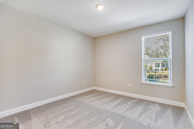 unfurnished room with a textured ceiling and carpet flooring