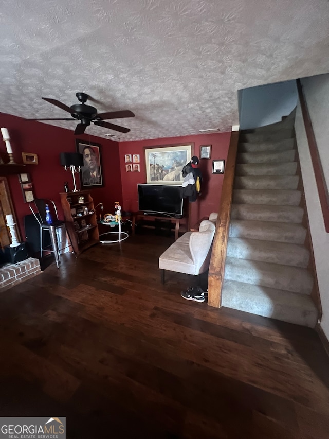 living room featuring a textured ceiling, hardwood / wood-style flooring, and ceiling fan