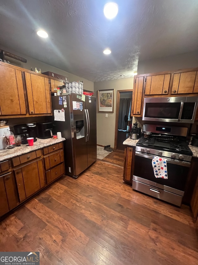 kitchen with dark wood-type flooring and appliances with stainless steel finishes