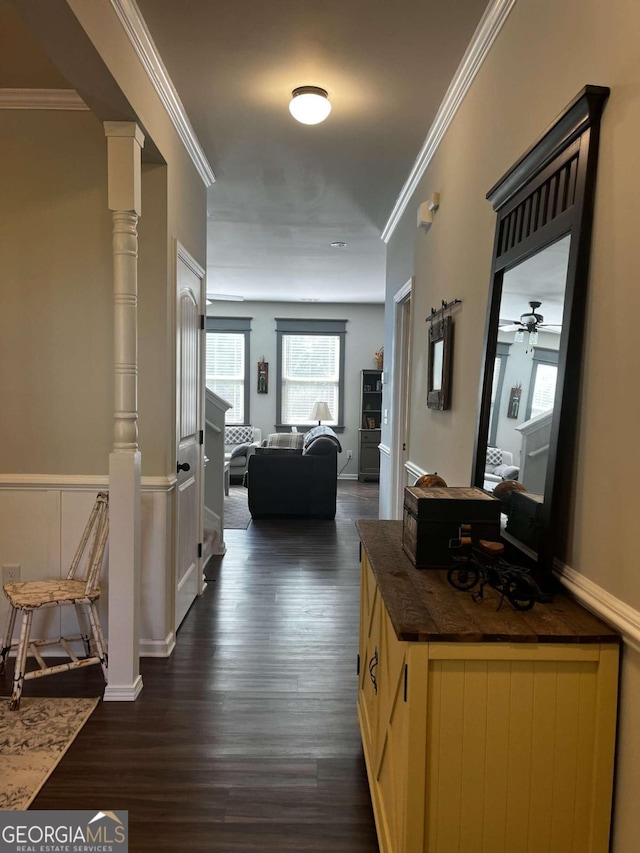 corridor with ornamental molding, dark hardwood / wood-style flooring, and ornate columns