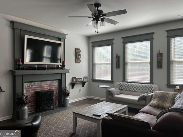 living room with ceiling fan, dark hardwood / wood-style floors, a brick fireplace, and a healthy amount of sunlight