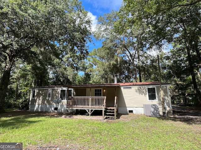 view of front facade featuring a wooden deck, a front lawn, and central AC