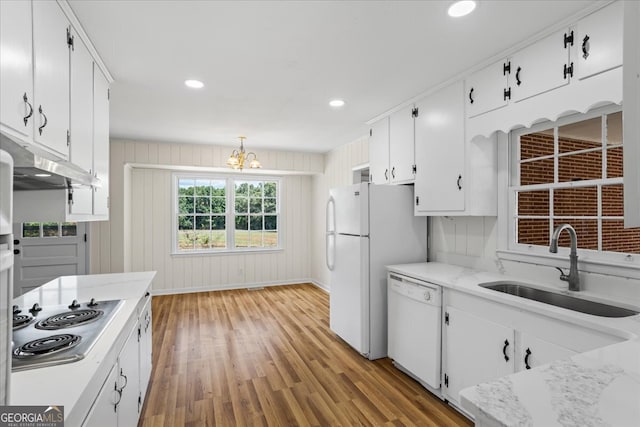 kitchen featuring sink, a notable chandelier, white cabinetry, light hardwood / wood-style flooring, and white appliances