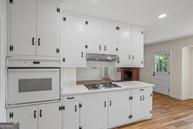 kitchen featuring stainless steel gas stovetop, white cabinetry, and white oven