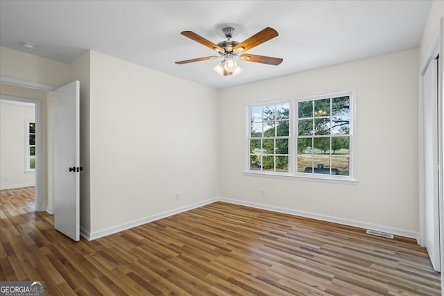 spare room with ceiling fan and dark hardwood / wood-style flooring