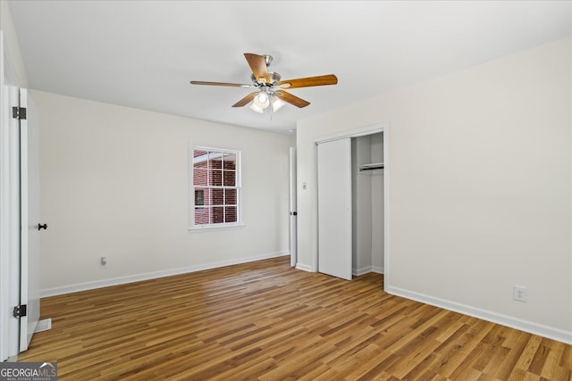 unfurnished bedroom featuring wood-type flooring, ceiling fan, and a closet