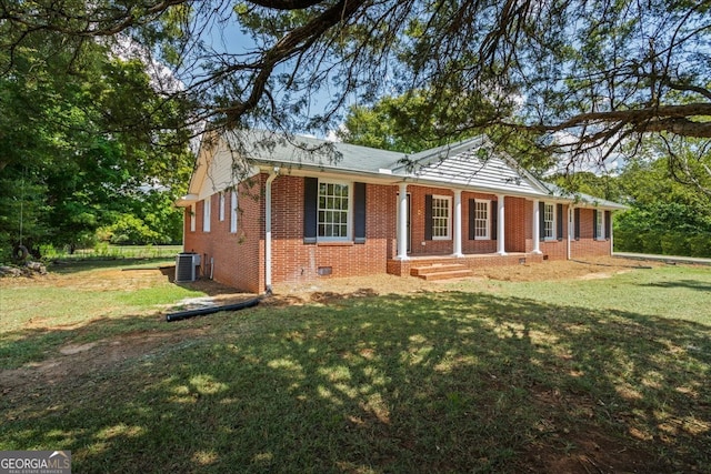 view of front of property with central air condition unit and a front yard