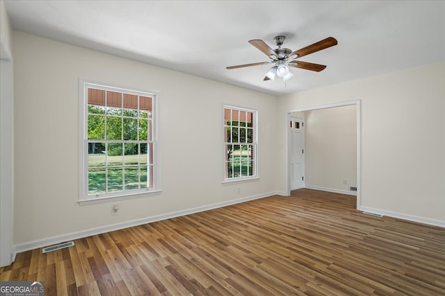 spare room featuring ceiling fan, plenty of natural light, and hardwood / wood-style floors