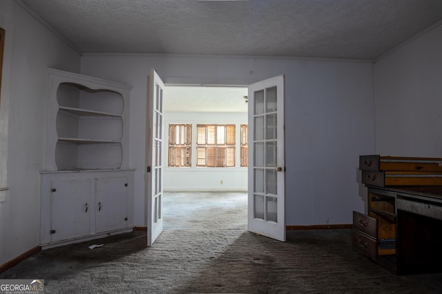 interior space featuring carpet floors, ornamental molding, a textured ceiling, and french doors