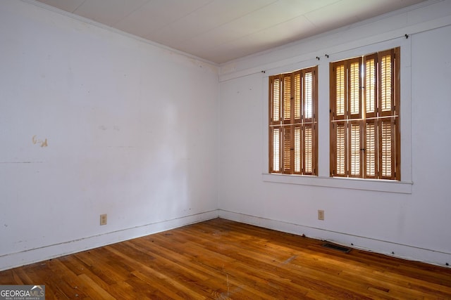 empty room featuring crown molding and hardwood / wood-style floors