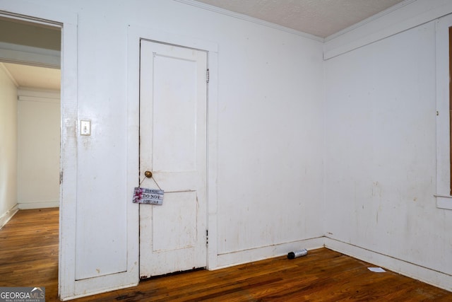 unfurnished room with wood-type flooring, a textured ceiling, and ornamental molding