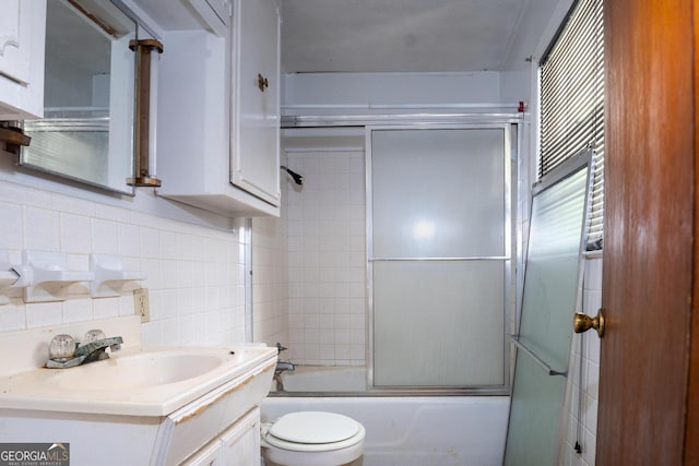 full bathroom with vanity, combined bath / shower with glass door, backsplash, tile walls, and toilet