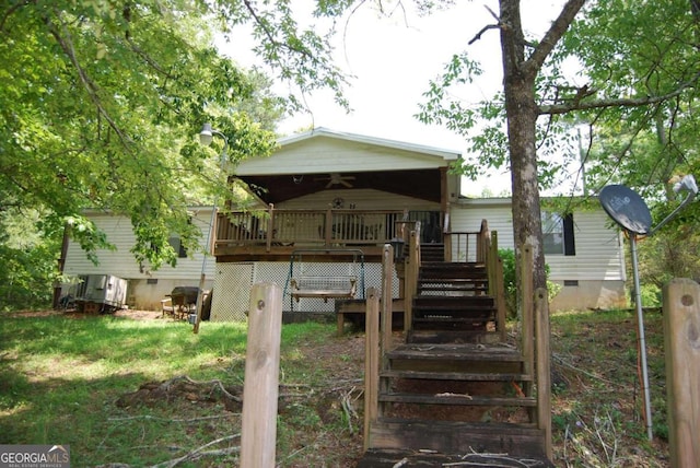 back of house featuring ceiling fan and a wooden deck