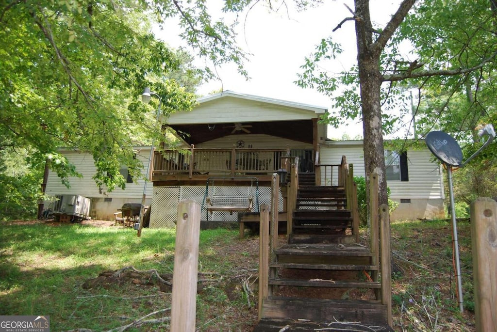 871 Pine Lake Dr SW, Sparta, GA 31087 - back of property featuring crawl space, stairs, and a deck