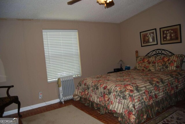 bedroom featuring a textured ceiling, ceiling fan, and radiator heating unit