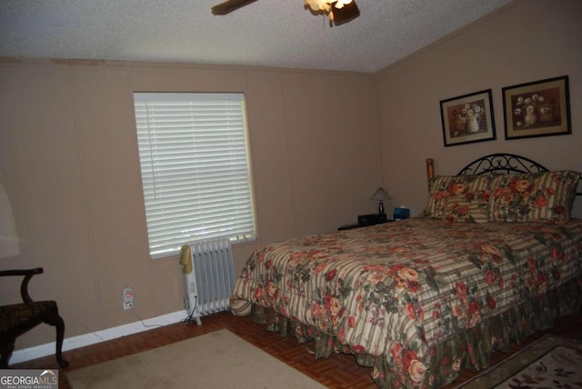 bedroom with a textured ceiling, a decorative wall, a ceiling fan, and radiator