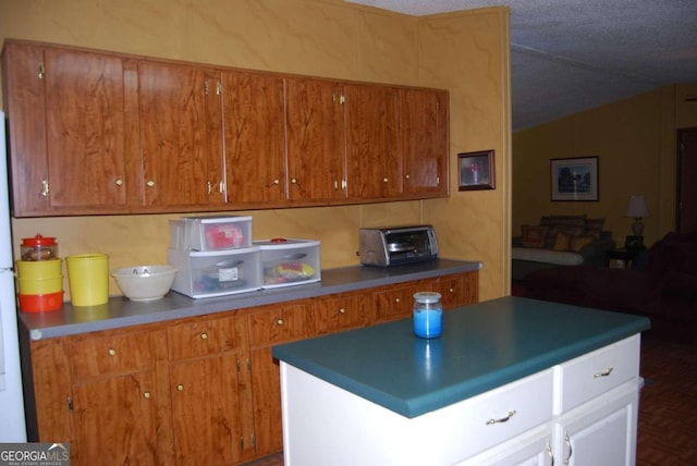 kitchen with brown cabinetry, lofted ceiling, a toaster, and dark countertops