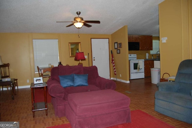 living room with a textured ceiling, sink, ceiling fan, and parquet floors