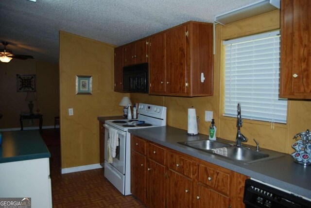 kitchen with sink, ceiling fan, black appliances, dark parquet flooring, and a textured ceiling