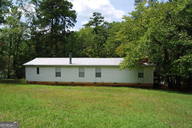 exterior space featuring crawl space, a yard, and metal roof