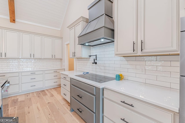 kitchen with white cabinetry, custom range hood, and lofted ceiling with beams