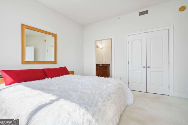 carpeted bedroom with connected bathroom and a closet