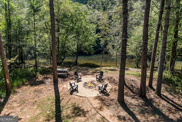 view of yard with an outdoor fire pit and a water view