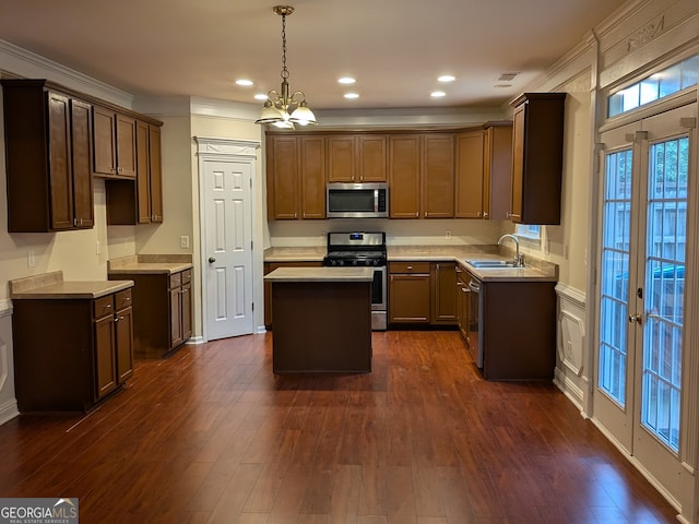 kitchen featuring crown molding, dark wood-type flooring, a center island, and stainless steel appliances