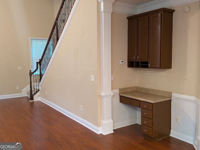 interior space with decorative columns, crown molding, and dark wood-type flooring