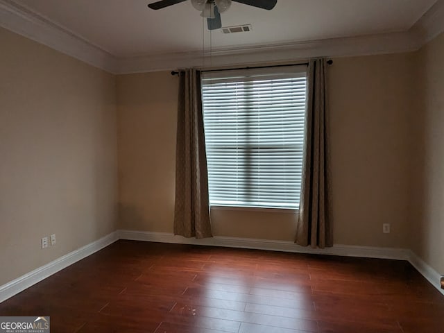 empty room featuring ornamental molding, ceiling fan, plenty of natural light, and dark wood-type flooring