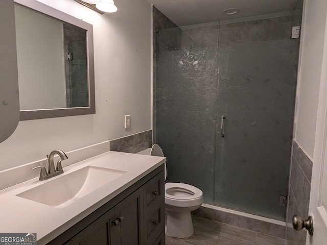 bathroom with vanity, toilet, and a shower with shower door