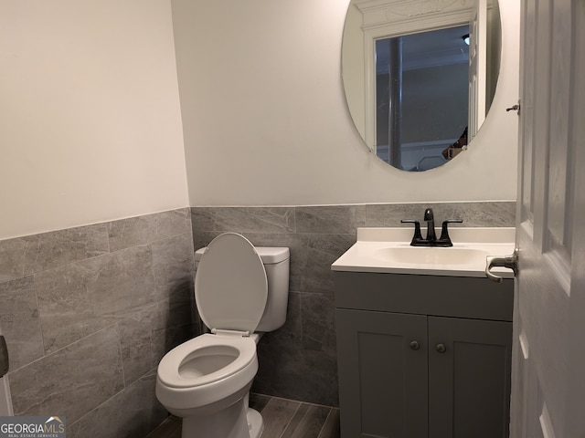 bathroom featuring vanity, tile walls, toilet, and wood-type flooring