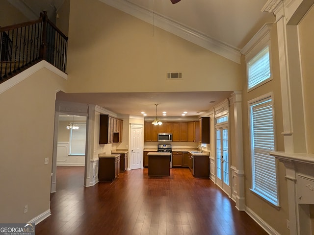 kitchen with appliances with stainless steel finishes, high vaulted ceiling, a kitchen island, and a healthy amount of sunlight