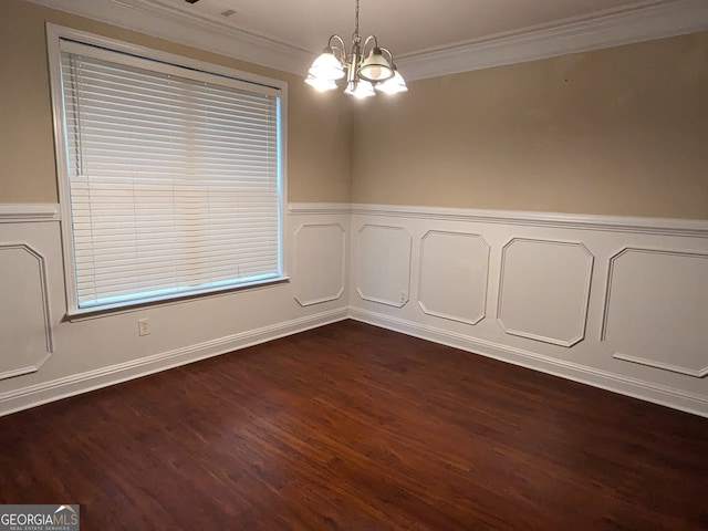 spare room featuring crown molding, dark wood-type flooring, and a chandelier