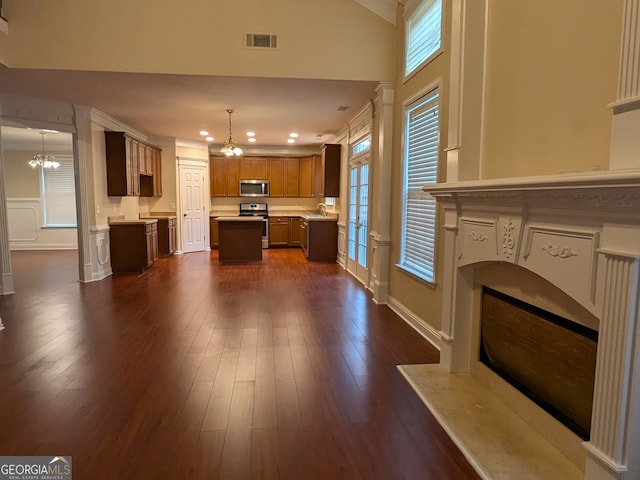 kitchen featuring an inviting chandelier, decorative light fixtures, dark hardwood / wood-style floors, appliances with stainless steel finishes, and a center island